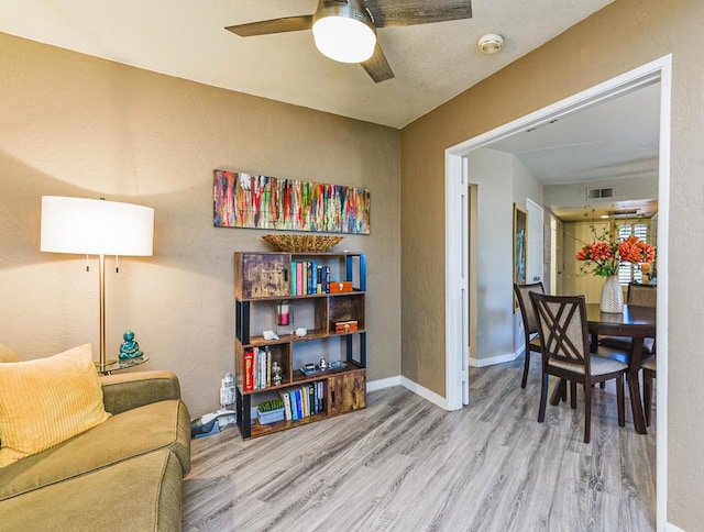 sitting room featuring wood-type flooring and ceiling fan