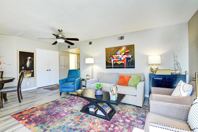 living room featuring ceiling fan and light hardwood / wood-style flooring