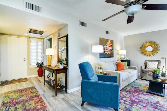 living room with ceiling fan and light hardwood / wood-style flooring