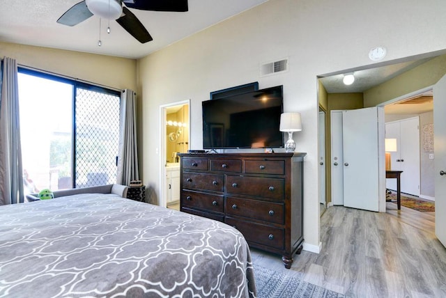 bedroom featuring vaulted ceiling, ceiling fan, light hardwood / wood-style flooring, and connected bathroom