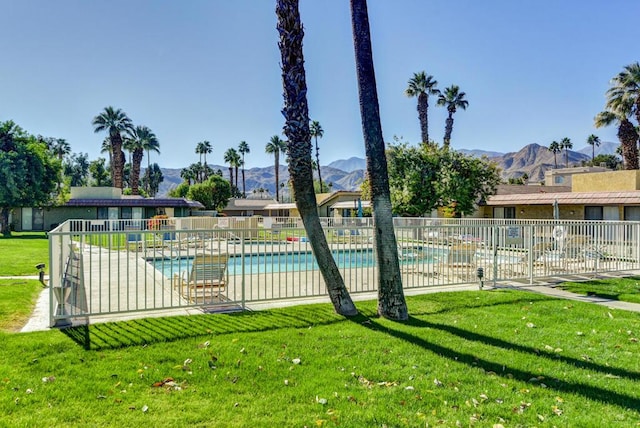 view of pool with a lawn, a patio, and a mountain view