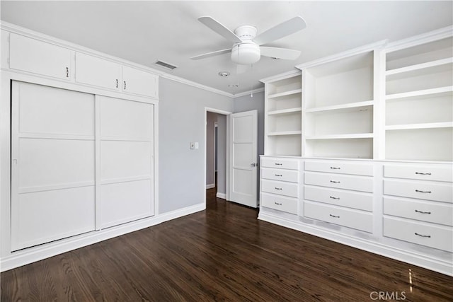 unfurnished bedroom with dark wood-type flooring, ceiling fan, a closet, and ornamental molding