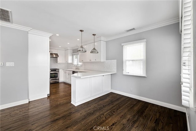 kitchen featuring hanging light fixtures, stainless steel range, crown molding, kitchen peninsula, and white cabinetry