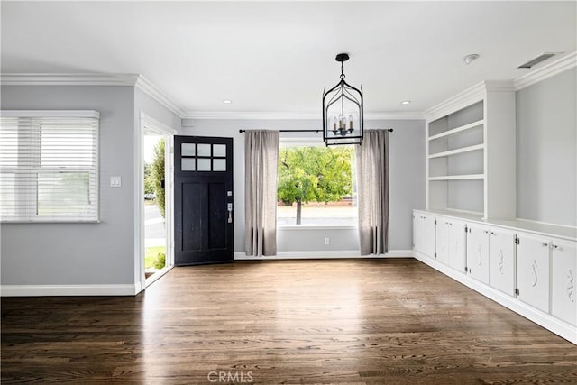 foyer entrance featuring dark hardwood / wood-style flooring, an inviting chandelier, and ornamental molding