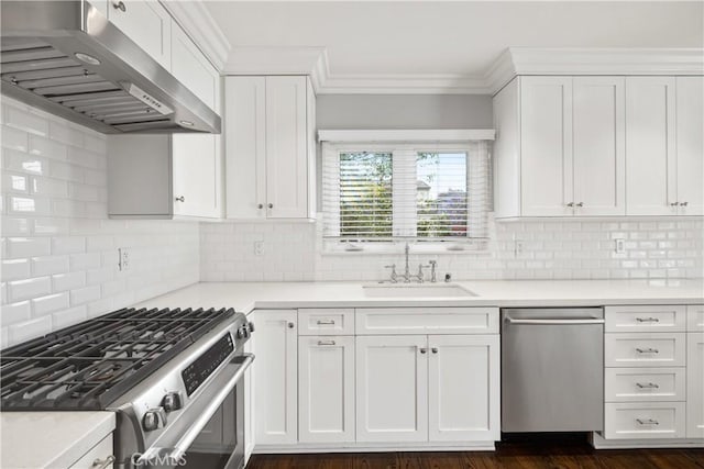 kitchen featuring white cabinets, extractor fan, appliances with stainless steel finishes, and tasteful backsplash