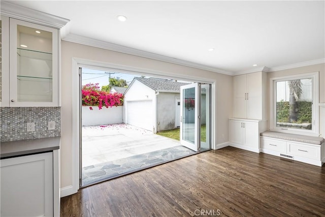 doorway to outside with dark hardwood / wood-style flooring and ornamental molding