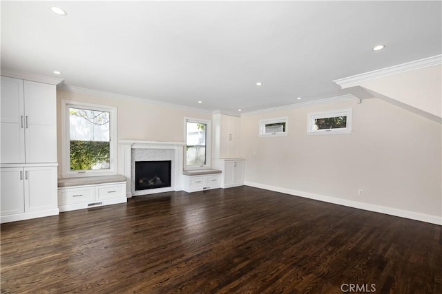 unfurnished living room with plenty of natural light, crown molding, and dark hardwood / wood-style floors