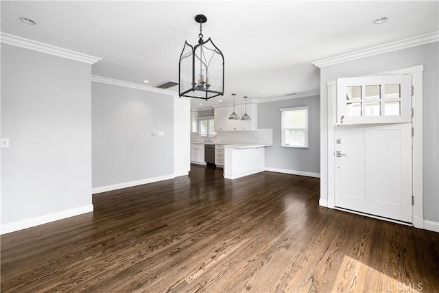 unfurnished living room with an inviting chandelier, ornamental molding, and dark hardwood / wood-style flooring