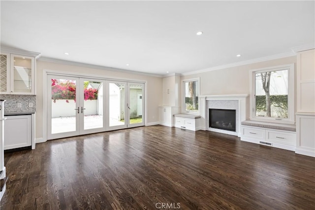 unfurnished living room featuring ornamental molding, dark hardwood / wood-style flooring, and a wealth of natural light