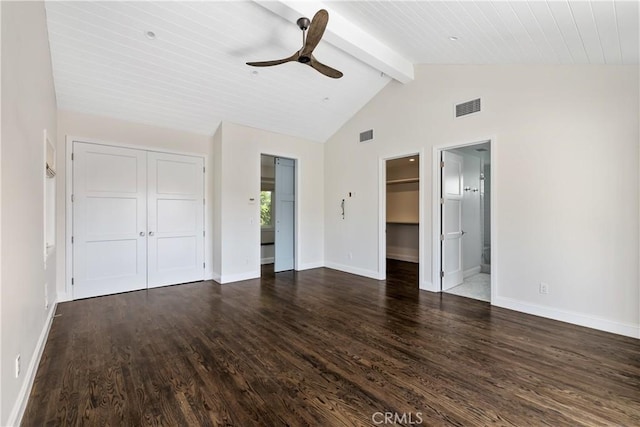 unfurnished bedroom with connected bathroom, ceiling fan, beamed ceiling, and dark wood-type flooring