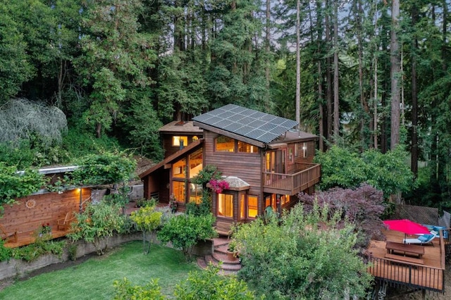 exterior space with a wooden deck, a yard, and solar panels