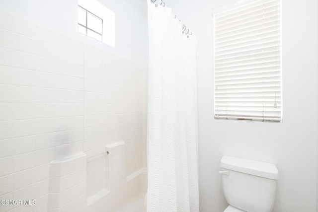 bathroom with toilet and shower / tub combo with curtain