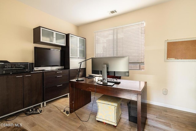 home office with light hardwood / wood-style flooring