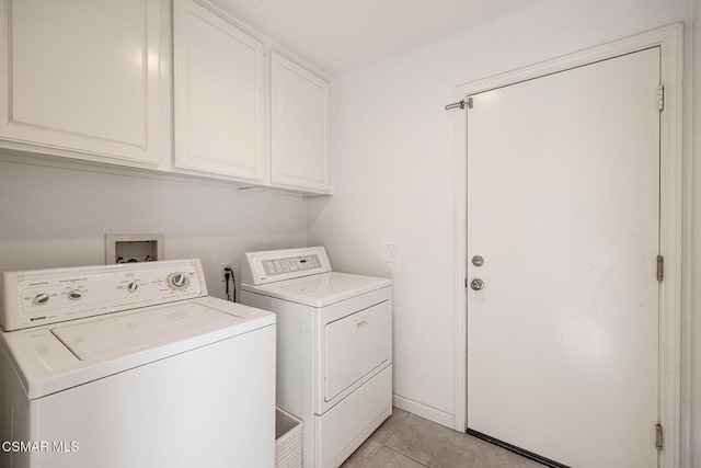 laundry area with light tile patterned floors, separate washer and dryer, and cabinets