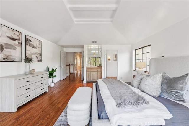 bedroom featuring multiple windows, dark hardwood / wood-style flooring, ensuite bath, and lofted ceiling with beams