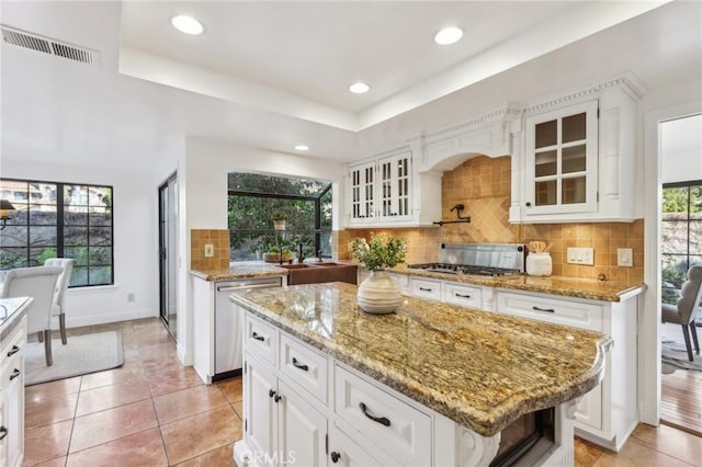 kitchen featuring light tile patterned floors, white cabinetry, stainless steel appliances, and a kitchen island