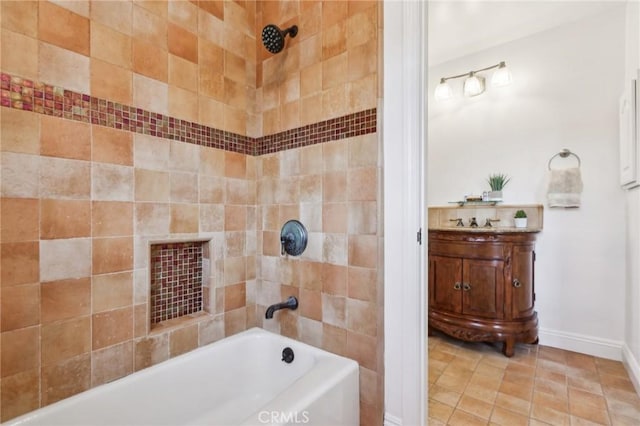 bathroom with tiled shower / bath, tile patterned flooring, and vanity