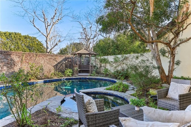 view of pool with an in ground hot tub and a gazebo