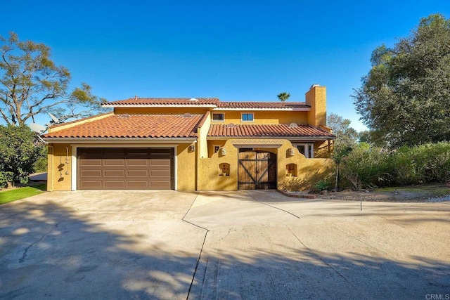 mediterranean / spanish home with a garage