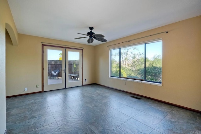 unfurnished room featuring french doors, ceiling fan, and plenty of natural light