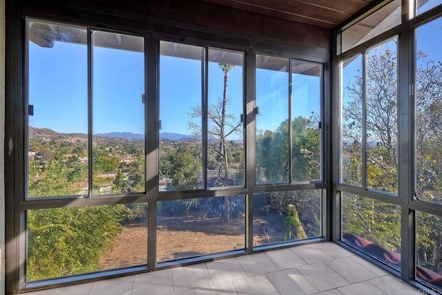 unfurnished sunroom featuring a mountain view