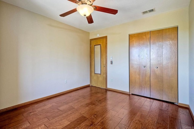 unfurnished bedroom featuring hardwood / wood-style flooring, ceiling fan, and a closet