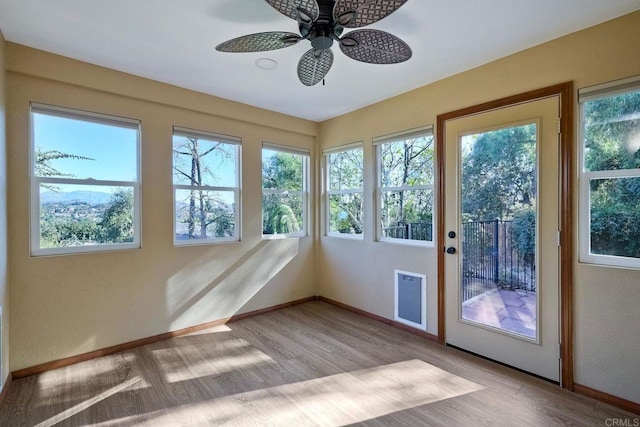 unfurnished sunroom featuring ceiling fan