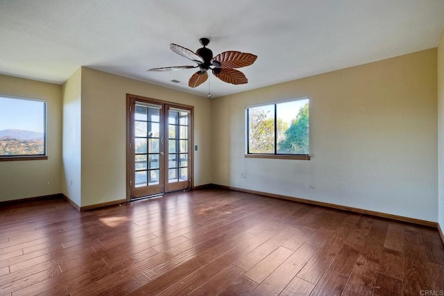 unfurnished room with french doors, ceiling fan, and dark hardwood / wood-style flooring