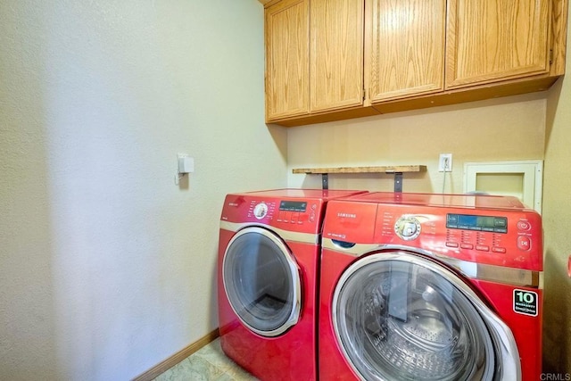 laundry room with washer and dryer and cabinets