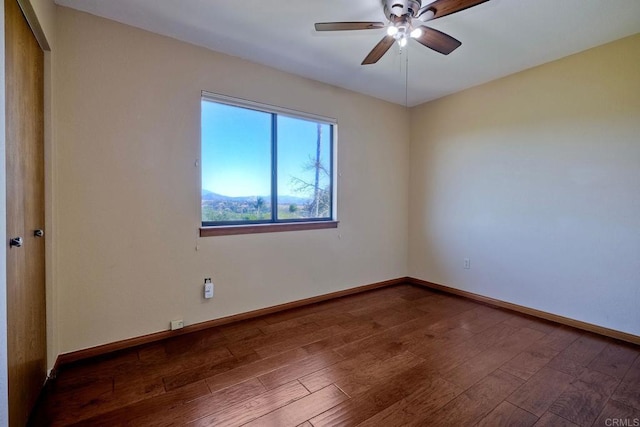 unfurnished room with ceiling fan and dark hardwood / wood-style flooring