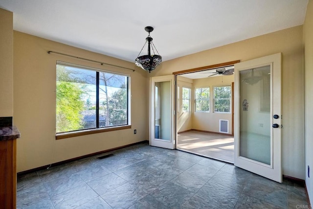 entryway featuring ceiling fan with notable chandelier and french doors