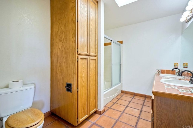 full bathroom featuring shower / bath combination with glass door, tile patterned floors, vanity, and toilet