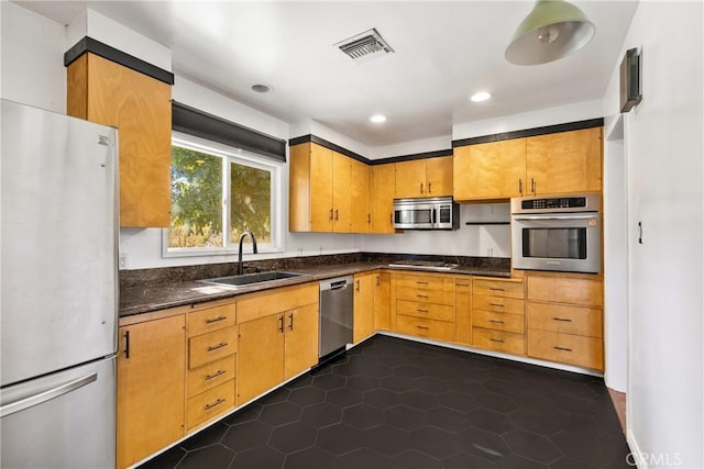 kitchen featuring sink, dark tile patterned flooring, and appliances with stainless steel finishes