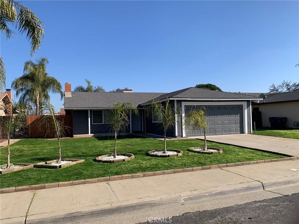 single story home with a front yard and a garage