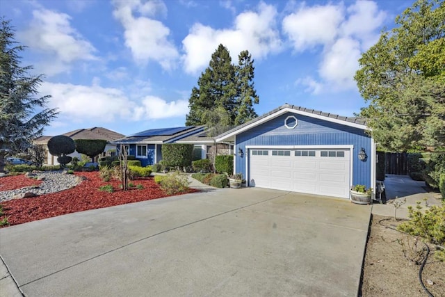 ranch-style house featuring solar panels and a garage