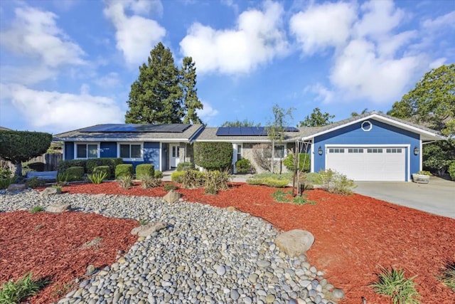 single story home featuring solar panels and a garage