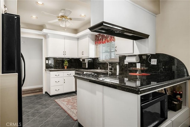 kitchen with black appliances, ceiling fan, dark tile patterned flooring, sink, and white cabinetry