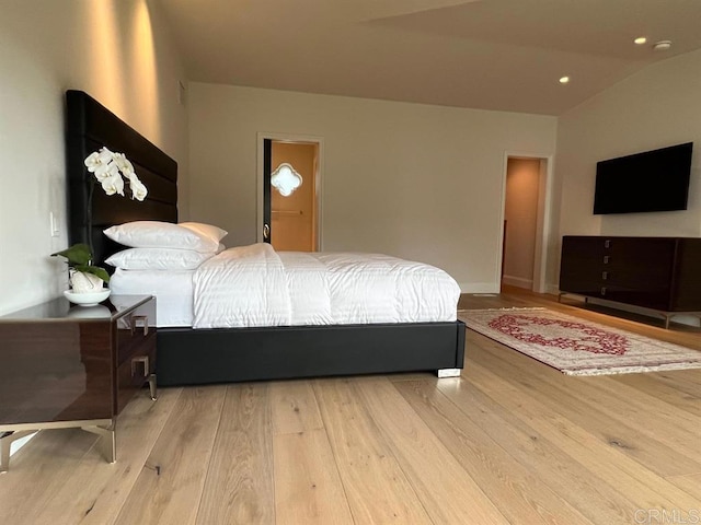 bedroom with light hardwood / wood-style floors and lofted ceiling