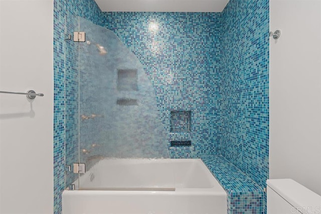 bathroom with toilet and tiled shower / bath combo