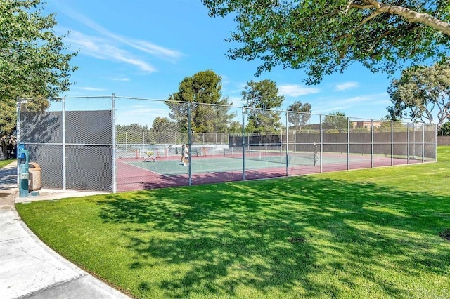 view of tennis court with a yard