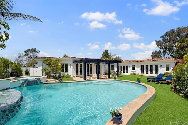 view of swimming pool featuring a yard, french doors, pool water feature, and an in ground hot tub