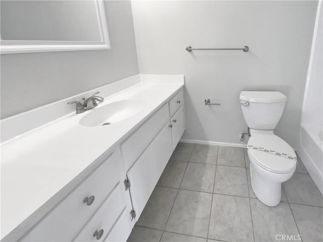 bathroom with toilet, vanity, and tile patterned flooring