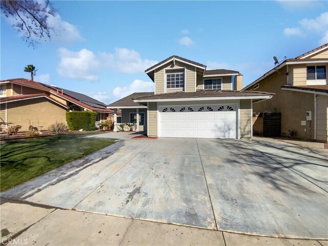 view of property with a garage and a front lawn