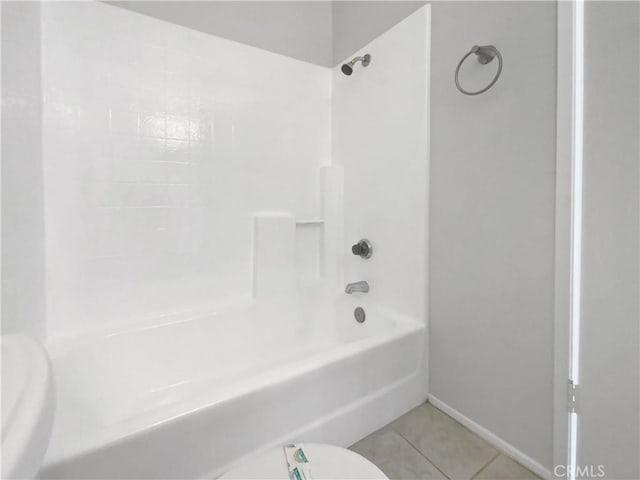 bathroom featuring tile patterned floors, toilet, and shower / washtub combination