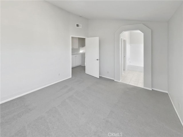 unfurnished bedroom with vaulted ceiling and light colored carpet