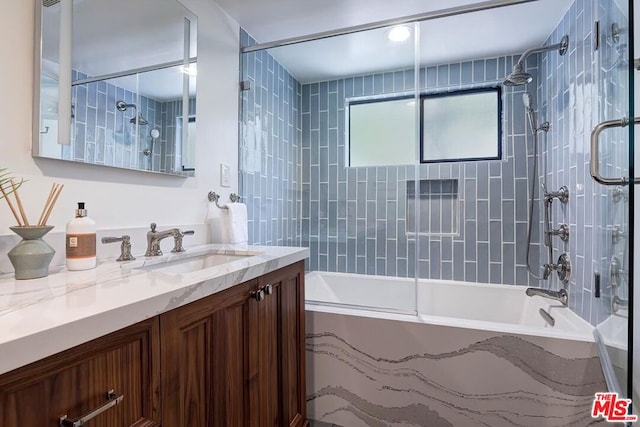 bathroom with tiled shower / bath and vanity