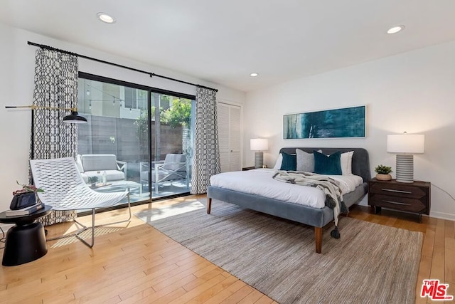 bedroom with hardwood / wood-style flooring, a closet, and access to exterior