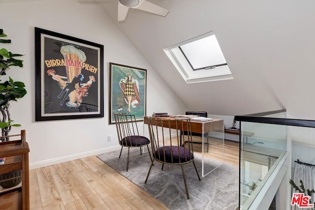 office with ceiling fan, hardwood / wood-style floors, and vaulted ceiling with skylight