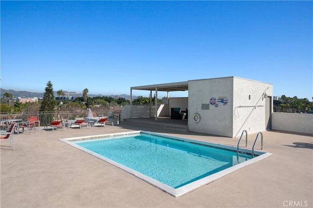 view of pool with a patio area and a mountain view