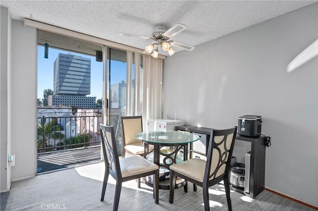 dining area featuring ceiling fan, a textured ceiling, floor to ceiling windows, and carpet flooring